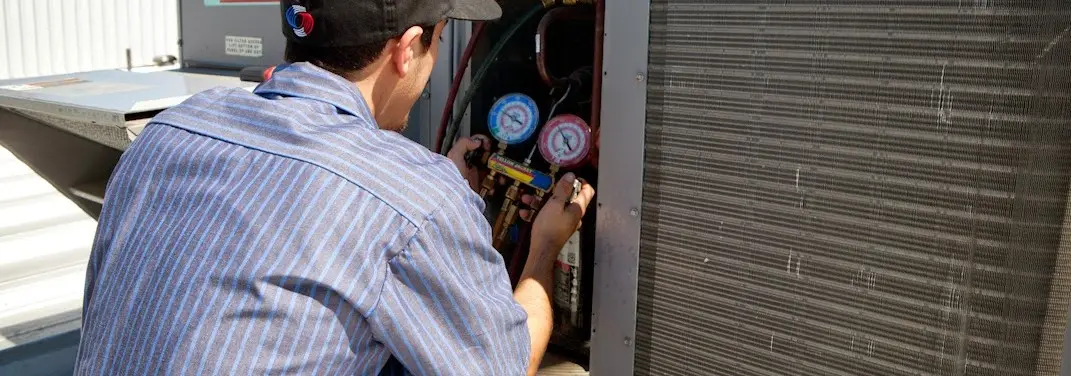 HVAC technician servicing a condenser unit in Beacon