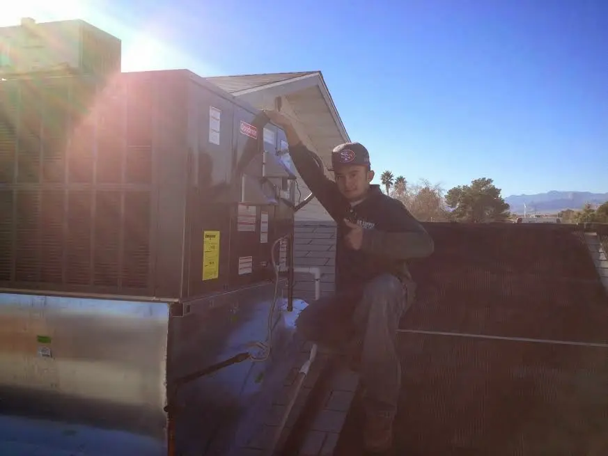 HVAC technician performing AC Tune-Up on a rooftop unit in Beacon